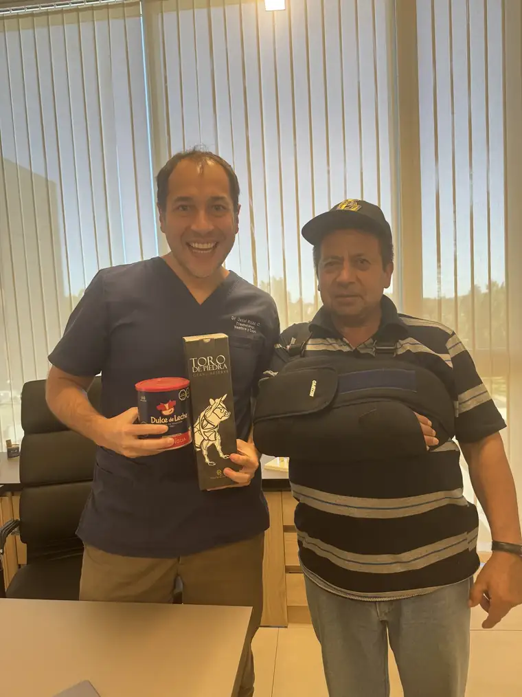 Paciente con inmovilizador de hombro junto al Dr. Daniel Rojas en el control a las 2 semanas de una reparación del manguito rotador