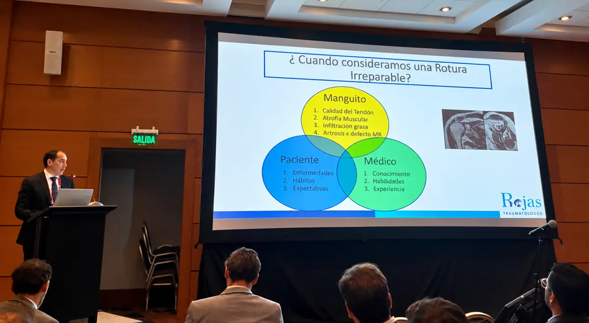 Dr. Daniel Rojas Castillo presentando en el 58.º Congreso Chileno de Ortopedia y Traumatología, frente a una diapositiva titulada «¿Cuándo consideramos una rotura irreparable?» con factores del manguito, del paciente y del médico